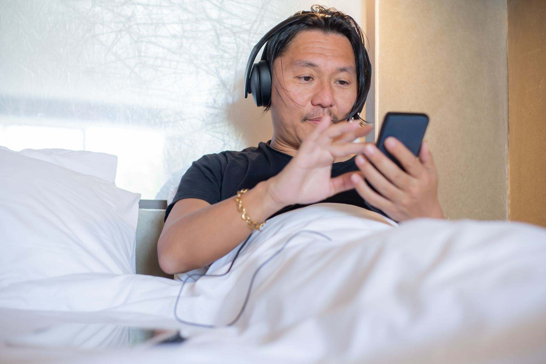 Personne avec un casque audio allongée dans un lit